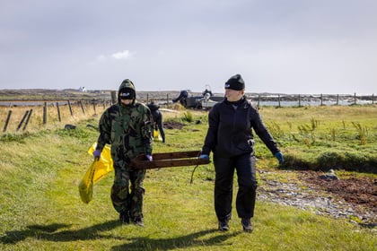 Two young girls carry trough during visit to Isle of Tiree