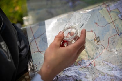 A cadet holding a compass and map during a navigation activity