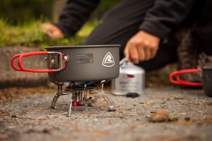 cooking on a camp stove in a grey foldable saucepan
