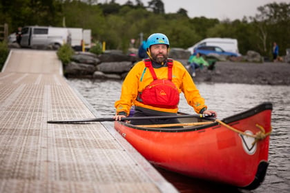 Adult instructor resting during paddle sport activities in his canoe