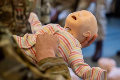 CPR mannequin baby being practiced CPR