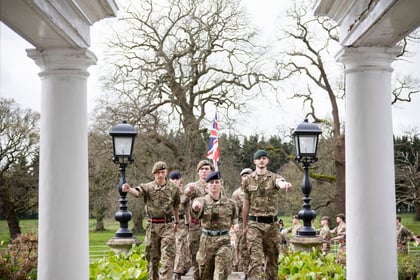 cadets in military uniform marching up to frimley park though white pillars