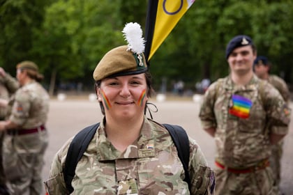 Adult volunteer with rainbow coloured paint on her cheeks