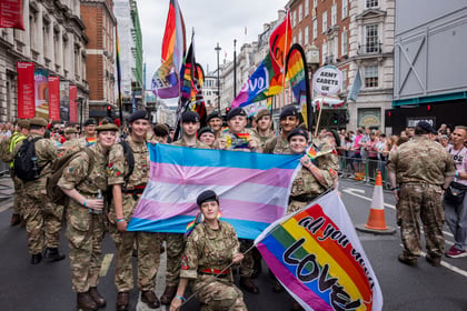 Group photo of cadets who attended Pride in London holding Pride flags.