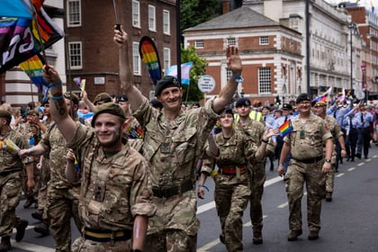 Adult volunteers wave at crowds that gathered at pride in London