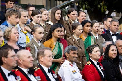 Cadets from the International Exchange gather for a group photo with some dressed in uniform