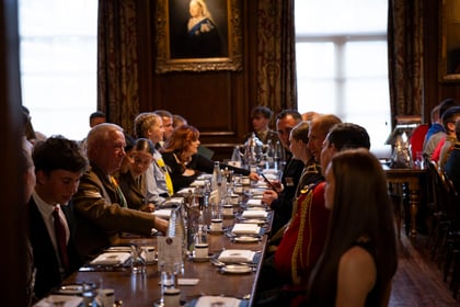 Cadets and volunteers sit at the International Exchange Dinner and chat to those around them at the table