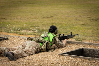 Cadet at shooting range with weapon lying down on gravel