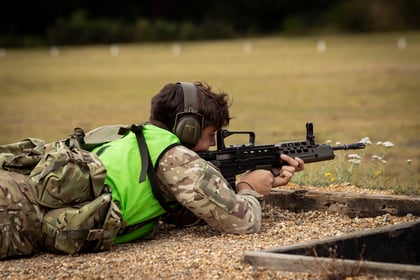 Cadet at shooting range with weapon lying down on gravel