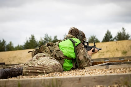 Cadet at shooting range with weapon lying down on gravel