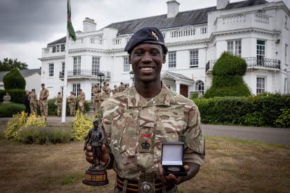Winner stands with his coin and trophy