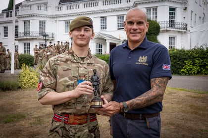 Cadet and sponsor stand together with his trophy with Frimley CTC in the background