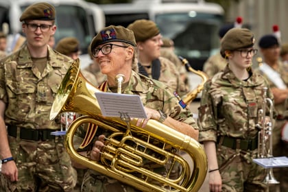Adult volunteer holding instrument and smiling