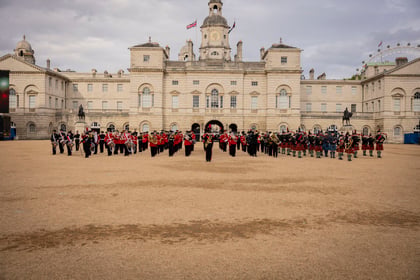 A group of cadets in full dress uniform marching in time to military music at the Horse Guards Spectacular in London.