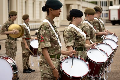 Cadets stand in a line and play drums.