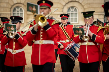 Military cadets with trumpets and drums playing as they march past spectators at the Horse Guards Musical Spectacular