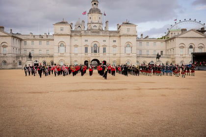 Cadets in ceremonial uniforms marching in formation while playing instruments at the Military Music Spectacular at Horse Guards Parade in London