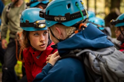 Adult volunteer speaks to cadet while doing mountain climbing