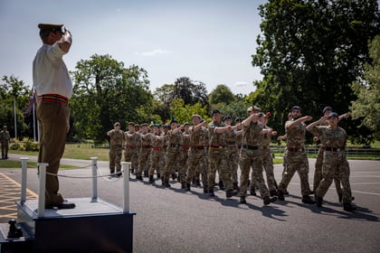 Cadets doing drill at the Master Cadet Final Parade saluting the CO from Frimley Park as he stands on a podium