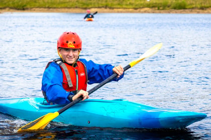 Cadet on canoe in a lake with helmet on