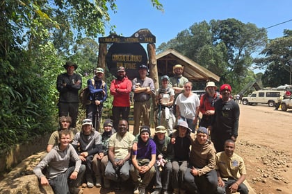 Team from Cambridgeshire ACF stands in front of Kilimanjaro National Park sign