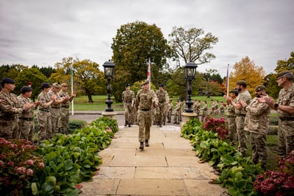 Master Cadets march up stairs with instructors on either side clapping