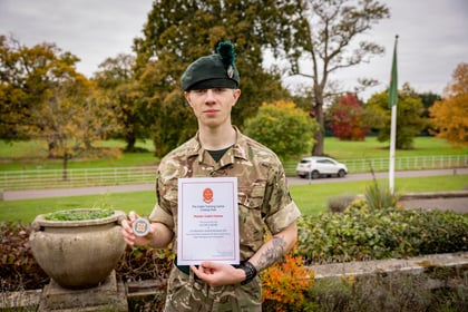 Male cadet holds coin and certificate after winning top student at Master Cadet Course 25_05