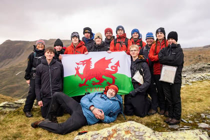 Group of cadets and volunteers pose with a Welsh flag