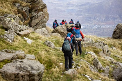Cadets walk in single file on rocky terrain