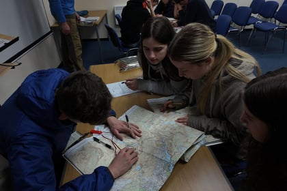 Cadet do a navigation exercise with map on front of them