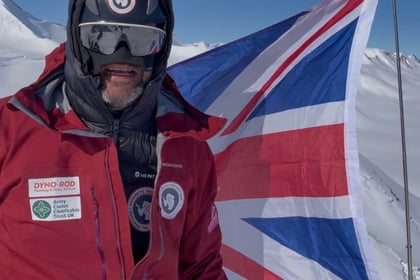 Jordan Wylie stands with the UK flag behind him
