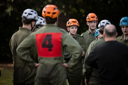 Cadets stand in a group dressed in safety gear before log run