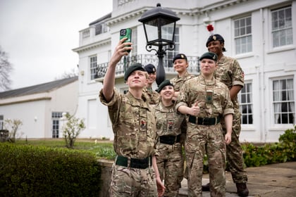Cadets smile while taking a selfie on the steps of Frimley Park