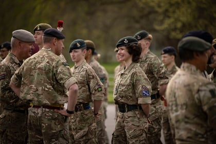 Female cadet smiles while speaking to instructors
