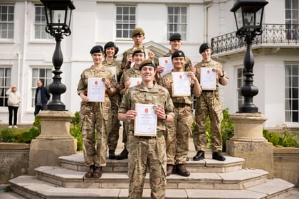A group of cadets stand proudly on the steps on CTC Frimley Park holding their certificates for Master Cadet Course