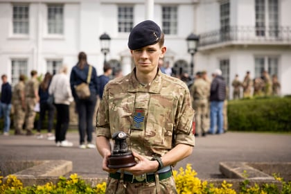 Top student from Master Cadet Course holds his trophy