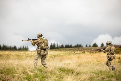 Cadets walk forward holding weapons up during fieldcraft exercise at Cadet Cambrian Patrol 2026
