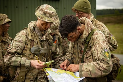 Male cadets reading map