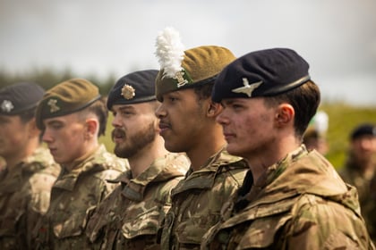 Male cadets stand in a row with their berets on