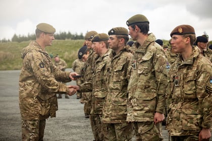 Male cadets receive medals from an adult instructor at Cadet Cambrian Patrol 2026