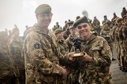 Cadet receives best CCF trophy from adult instructor