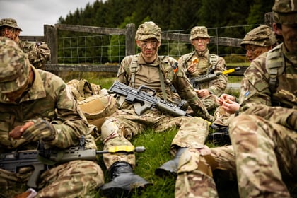 Male cadets sit down during a break in a fieldcraft exercise at Cadet Cambrian Patrol 2026