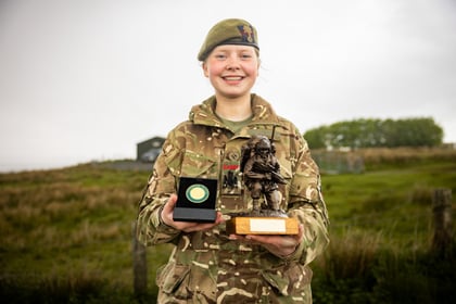 Female cadets holds medal and trophy