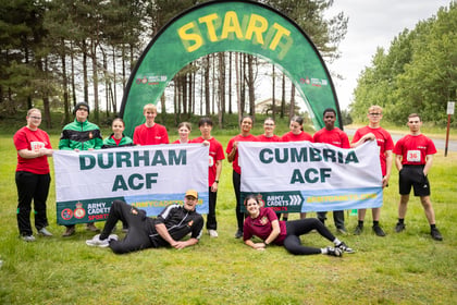 Two teams hold their team banners at the start line