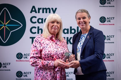 Sally Orange presents an award to a lady in a pink dress