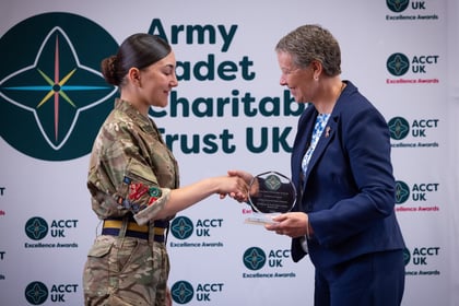 Sally Orange shakes hands with a female cadet while presenting her with an award