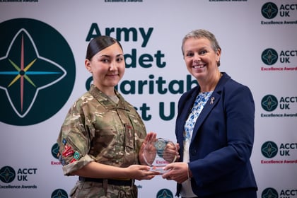 Sally Orange presents an award to a female cadet in uniform