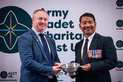 Hari Budha Magar presents silver cup to a man in a blue suit