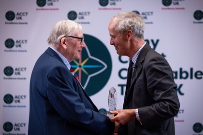 Two elderly men with grey hair presents an award