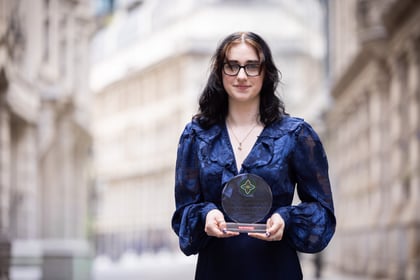 Female cadet wearing a blue blouse holds her ACCT UK Award